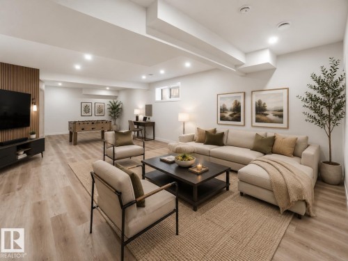 Spacious open-concept recreation room featuring recessed lighting, light wood-finish flooring, and a textured accent wall - 3320 Chickadee Drive, Edmonton, AB 