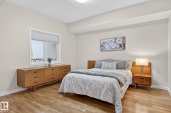 Bedroom featuring wood-finish flooring, a contemporary window with cellular blinds, light-toned walls, and a flat ceiling - 