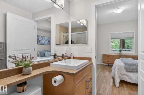 Bathroom featuring a contemporary vessel sink, light wood-finish cabinetry, and a full-width mirror - 208 5 Gate Avenue, St. Albert, AB 