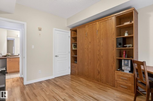 Built-in wood-finish cabinetry featuring a folding bed, integrated shelving, and drawer storage - 208 5 Gate Avenue, St. Albert, AB 