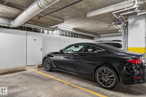 Concrete parking area featuring overhead exposed ductwork and utility piping - 208 5 Gate Avenue, St. Albert, AB 