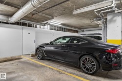 Concrete parking area featuring overhead exposed ductwork and utility piping - 