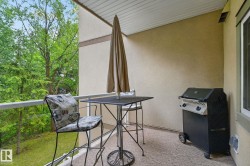 Covered balcony featuring a textured stucco exterior, white soffit, and railing - 