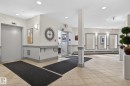 Common area featuring neutral wall tones with grey trim, recessed lighting, wall sconces, large format tile flooring, and a glass-paneled entrance - 208 5 Gate Avenue, St. Albert, AB 