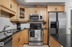 Kitchen featuring light wood cabinetry, granite-style countertops, and stainless steel appliances - 