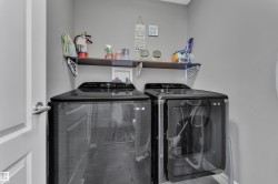 Dedicated laundry area featuring a dark wood-finish wall shelf, contemporary gray wall paint, and durable tile flooring - 