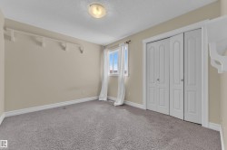 Carpeted room featuring a single window with white trim, a flush-mount ceiling light, and bi-fold closet doors - 