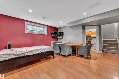Finished basement space featuring wood-finish flooring and recessed lighting - 6116 11 Avenue, Edmonton, AB 