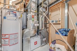 Water heater and furnace units featuring visible ductwork and piping - 