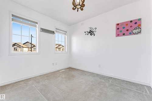 Bright interior space featuring white walls and light gray carpet flooring - 5928 12 Avenue, Edmonton, AB 