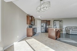 Open-concept kitchen and dining area featuring dark wood cabinetry, stainless steel appliances, granite countertops, and an island with a breakfast bar - 