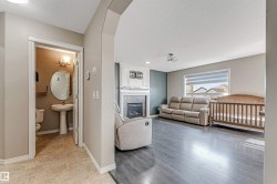 Living area with dark wood-finish flooring and a fireplace featuring a white mantel and tile surround - 