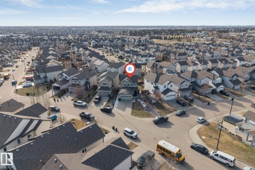 Contemporary residential dwelling featuring a light gray exterior, dark shingle roofing, and an attached two-car garage - 5928 12 Avenue, Edmonton, AB 
