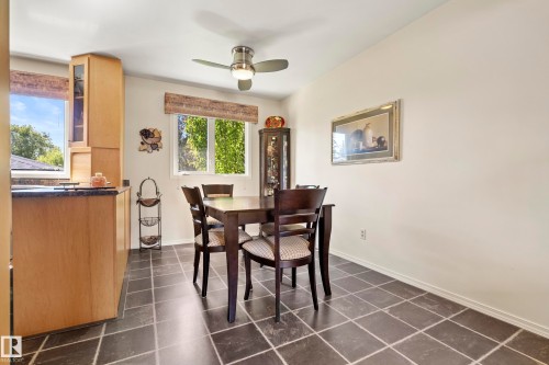 Dining area featuring dark square tile flooring - 3208 70 Street, Edmonton, AB 