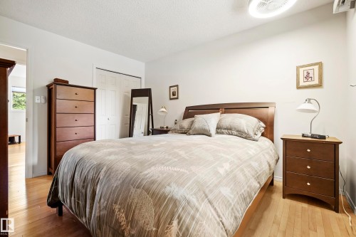 Bedroom featuring wood-finish flooring, a paddle-style ceiling fan, and white walls - 3208 70 Street, Edmonton, AB 