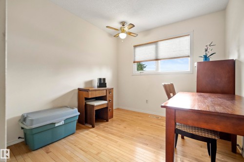 Bright room featuring wood-finish flooring, a white ceiling with a ceiling fan, and light-colored walls - 3208 70 Street, Edmonton, AB 