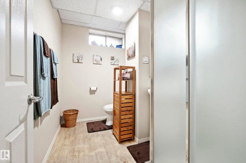 Bathroom with wood-finish flooring and a white toilet - 3208 70 Street, Edmonton, AB 