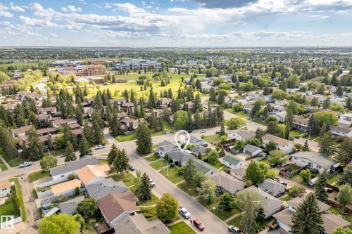 Aerial perspective showcasing a residential neighborhood with ample green space and distant institutional buildings - 3208 70 Street, Edmonton, AB 