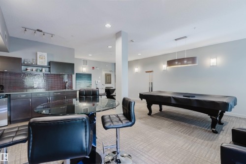 Game room featuring a billiards table, recessed lighting, and a modern wet bar with dark cabinetry and a mosaic tile backsplash - 217 508 Griesbach Parade, Edmonton, AB 
