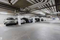 Covered parking garage featuring concrete flooring, concrete walls, and overhead lighting - 