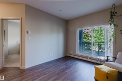 Warm wood-finish flooring complements light-colored walls in this inviting living space - 
