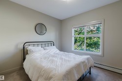 Carpeted room with a large window, neutral wall paint, white trim, and baseboard heating - 