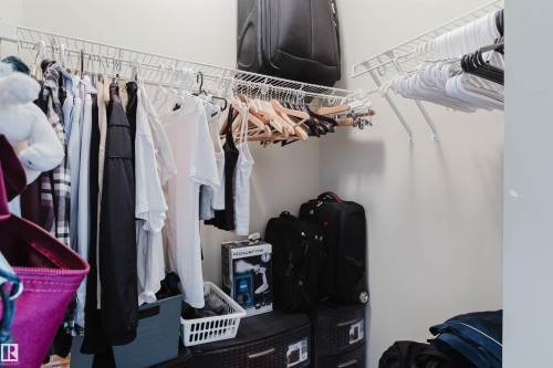 Walk-in closet with white wire shelving and hanging rods - 217 508 Griesbach Parade, Edmonton, AB 