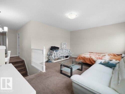 Carpeted loft area featuring neutral wall tones and a ceiling-mounted light fixture - 3756 8 Street, Edmonton, AB 