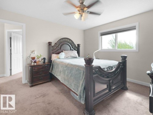 Carpeted room with a large window, a ceiling fan with integrated lighting, and neutral wall tones - 3756 8 Street, Edmonton, AB 