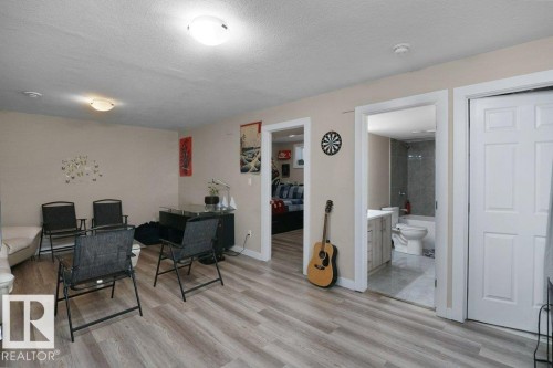 Spacious interior with light wood-finish flooring, neutral wall tones, and recessed lighting - 3756 8 Street, Edmonton, AB 