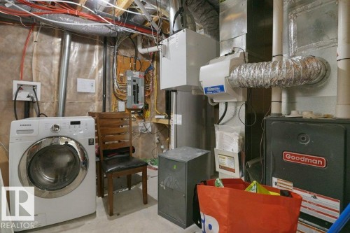 Utility area featuring a water heater, furnace, and exposed ceiling joists with wiring - 3756 8 Street, Edmonton, AB 