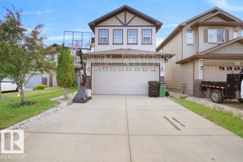 Two-story residence featuring light-colored siding with dark trim accents and a prominent front-facing gable - 3756 8 Street, Edmonton, AB 