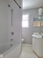 Bathroom featuring a white tub and shower combination with chrome fixtures - 