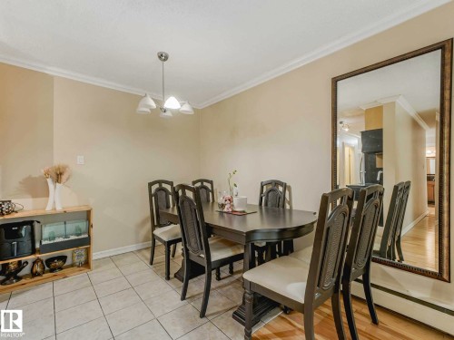 Dining area featuring neutral wall paint, crown molding, and ceramic tile flooring - 403 10165 113 Street, Edmonton, AB 