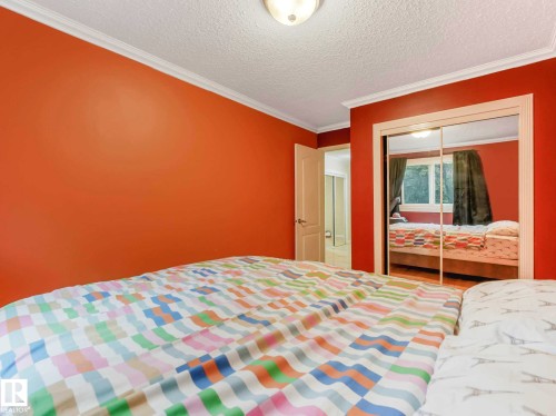Bedroom featuring a neutral wall color, white crown molding, and a ceiling-mounted light fixture - 403 10165 113 Street, Edmonton, AB 