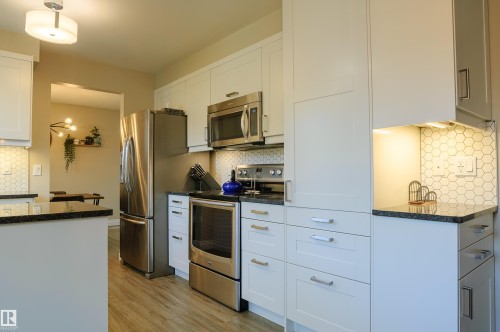 Modern kitchen featuring white cabinetry and stainless steel appliances - 58 Lodgepole Crescent, St. Albert, AB 