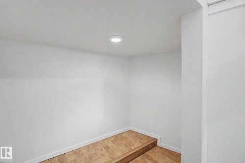 Compact area featuring light-toned wood-finish flooring, white walls, and a recessed ceiling light fixture - 11150 83 Avenue, Edmonton, AB 