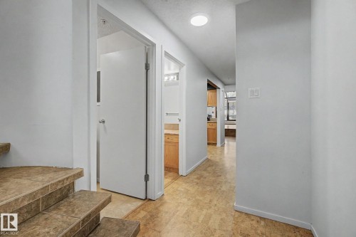 Foyer featuring tile-finish stairs, light-toned flooring, and recessed lighting - 11150 83 Avenue, Edmonton, AB 