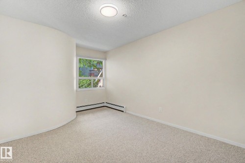Carpeted room with a curved wall feature - 11150 83 Avenue, Edmonton, AB 