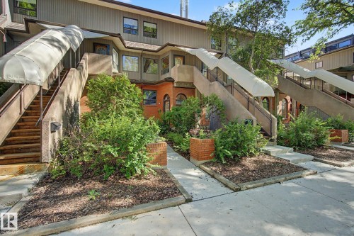 Contemporary multi-level exterior with concrete stairs, individual awning coverings, and mature landscaping - 11150 83 Avenue, Edmonton, AB 