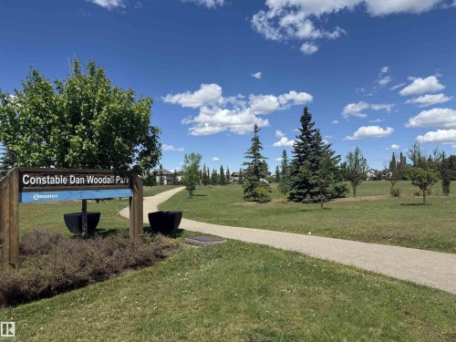 Gravel pathway traversing a green space with mature trees and landscaping - 7224 7327 South Terwillegar Drive, Edmonton, AB 