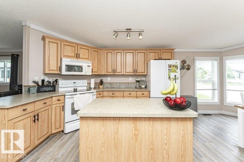Kitchen featuring light wood-finish cabinetry, a tiled backsplash, and light-colored countertops - 233 Oak Wood Drive, Edmonton, AB 