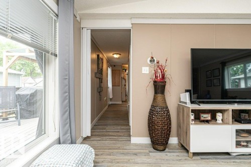 Spacious interior featuring wood-finish flooring, light tan paneled walls, and white trim - 233 Oak Wood Drive, Edmonton, AB 