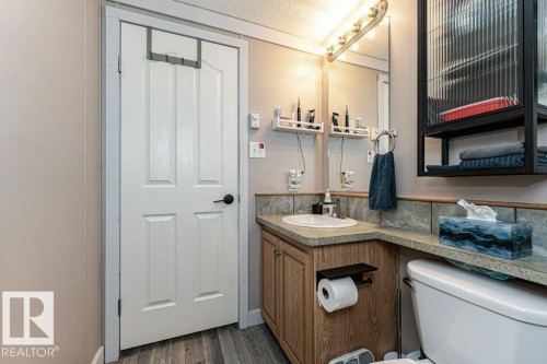 Bathroom vanity featuring an integrated sink, laminate countertop, and wood-finish cabinetry - 233 Oak Wood Drive, Edmonton, AB 