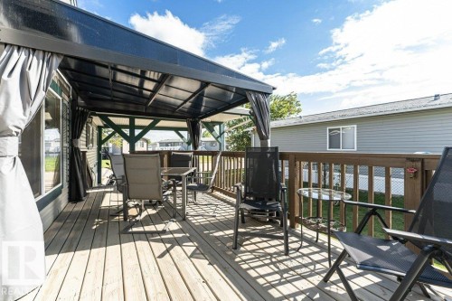 Expansive wooden deck featuring a full-coverage pergola with a translucent roof and retractable side curtains - 233 Oak Wood Drive, Edmonton, AB 