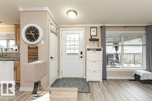 Entryway featuring a white paneled door with frosted glass inserts, a ceiling-mounted light fixture, and wood-finish flooring - 233 Oak Wood Drive, Edmonton, AB 