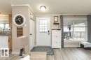 Entryway featuring a white paneled door with frosted glass inserts, a ceiling-mounted light fixture, and wood-finish flooring - 233 Oak Wood Drive, Edmonton, AB 