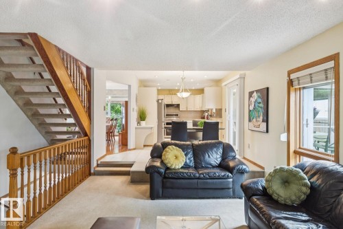 Carpeted living area with wood banister staircase and trim - 15804 80 Street, Edmonton, AB 