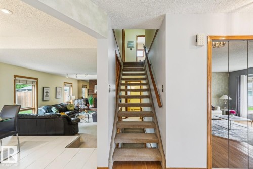 Carpeted staircase with wood handrail, leading to an upper level - 15804 80 Street, Edmonton, AB 