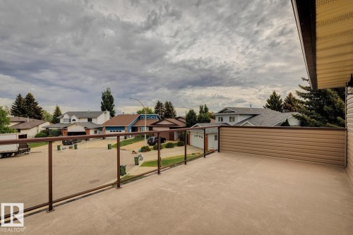 Expansive outdoor balcony featuring a glass panel railing system and durable concrete surface - 15804 80 Street, Edmonton, AB 